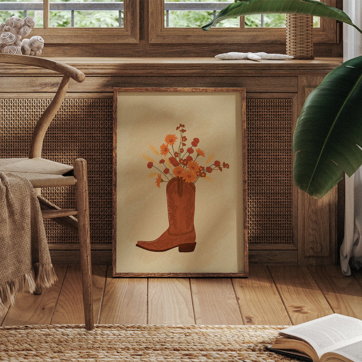 Framed artwork of a cowboy boot with flowers on a wooden floor.