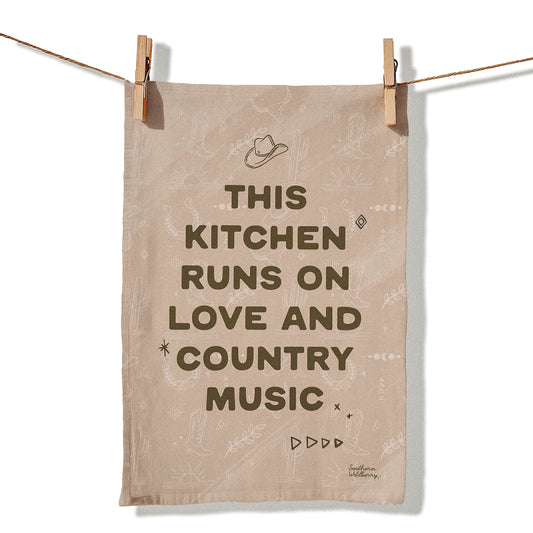 Western tea towel with the quote “This Kitchen Runs On Love And Country Music” featuring cowboy hat and country inspired illustrations in neutral tones